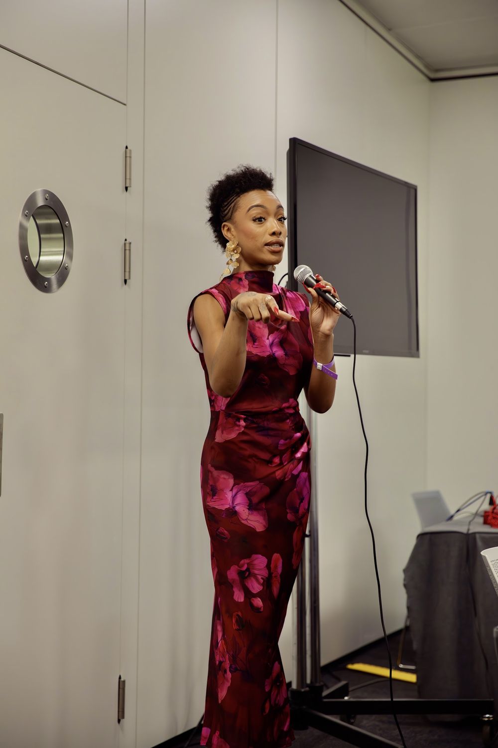 Paige speaking into a microphone at a book event