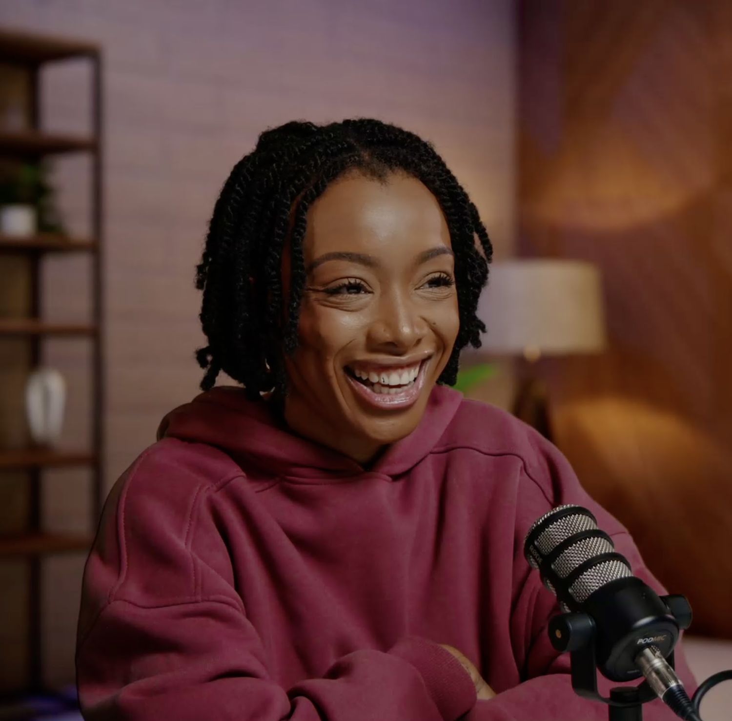Paige laughing at a podcast microphone