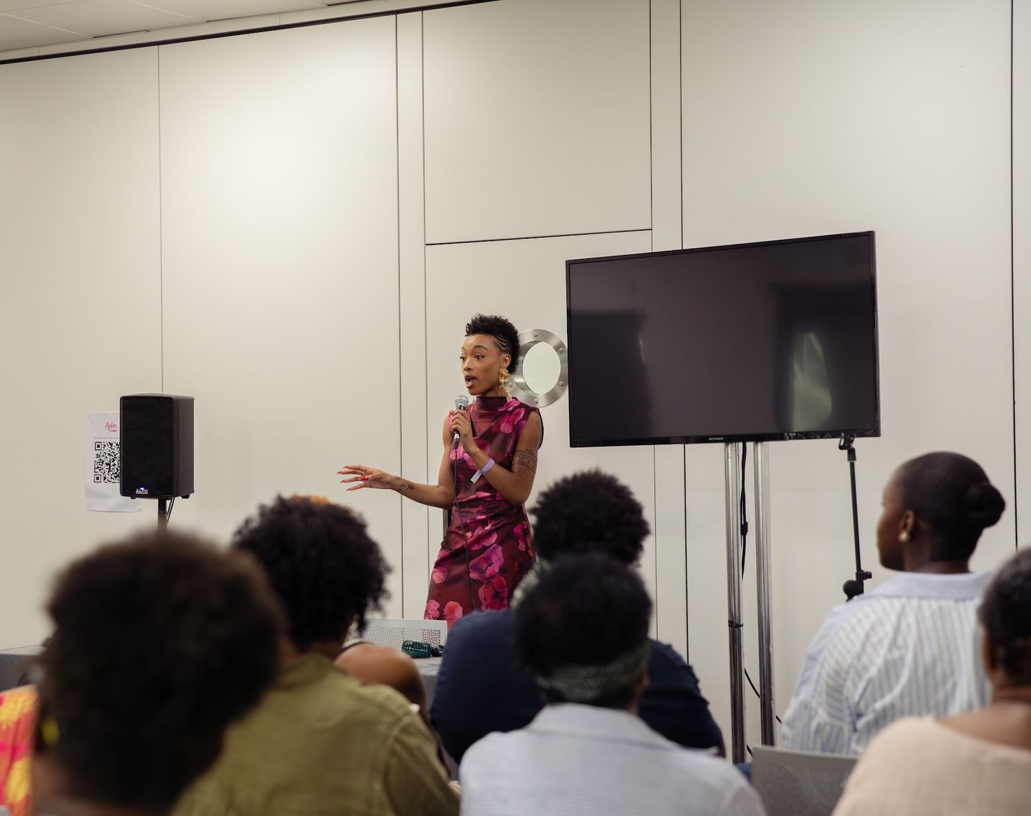 Paige leading a workshop in front of a seated audience
